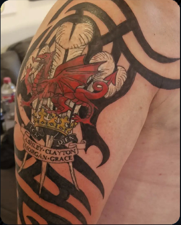 Welsh dragon and crown tattoo incorporated into a tribal upper arm design