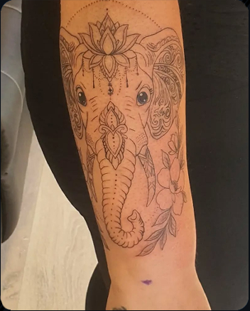 Ornamental elephant tattoo with lotus flower and floral details on the forearm